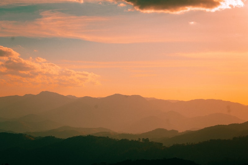 Vista panorâmica de Campos do Jordão ao entardecer, com montanhas e vegetação típica da Serra da Mantiqueira