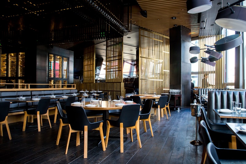 Interior de restaurante romântico com iluminação suave e mesas preparadas para jantar a dois