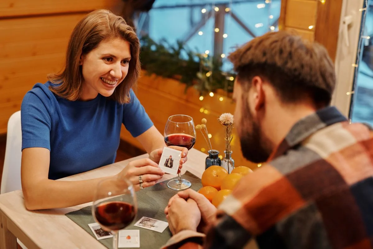 Casal adulto jogando cartas com vinho em clima romântico discreto
